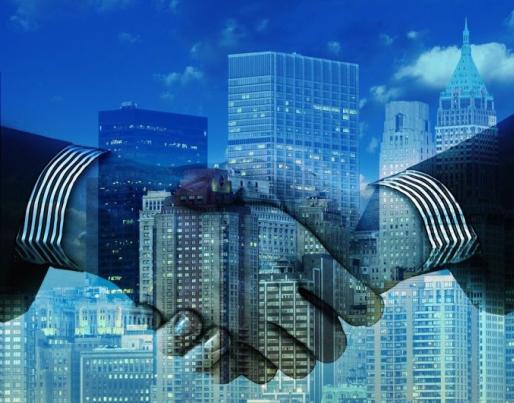Shaking hands and buildings in the background