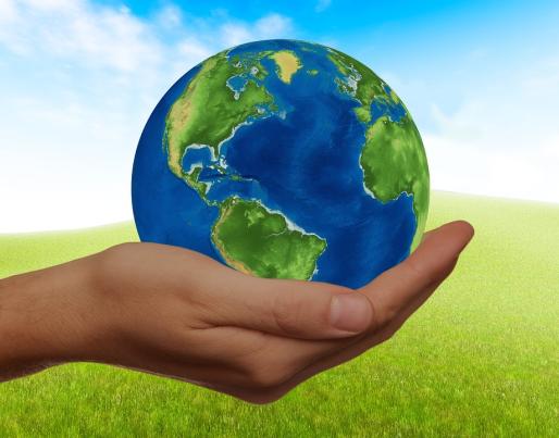A hand holding a globe