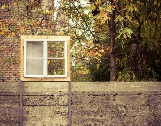 A window on a concrete wall with trees behind