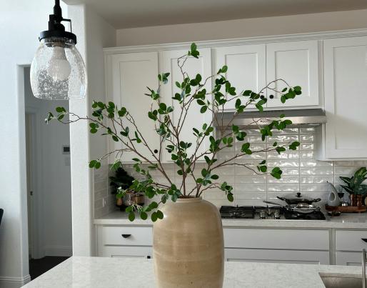 A vase with a plant in a kitchen