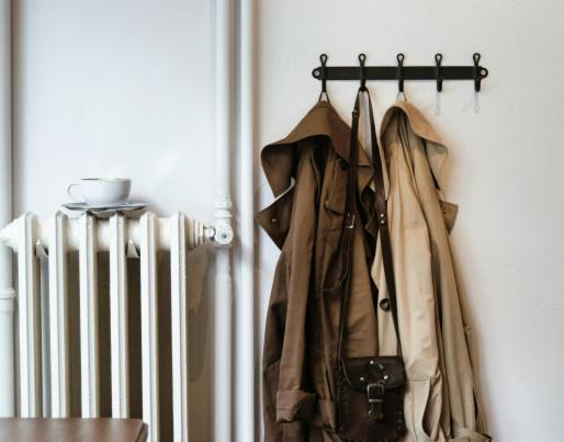 A radiator and coats inside a house