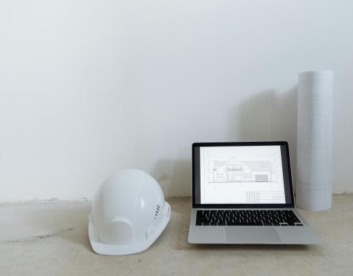 A laptop and a builder's helmet