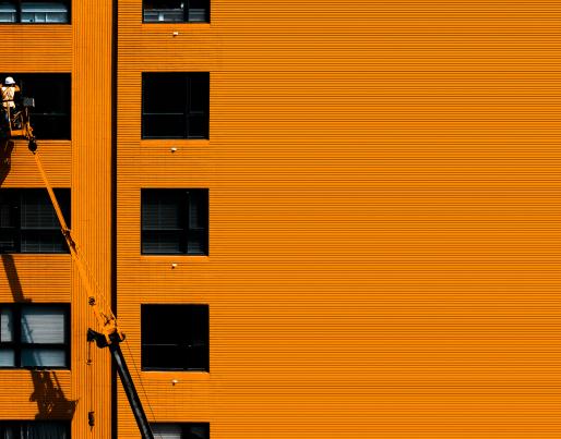 An orange building and a construction worker