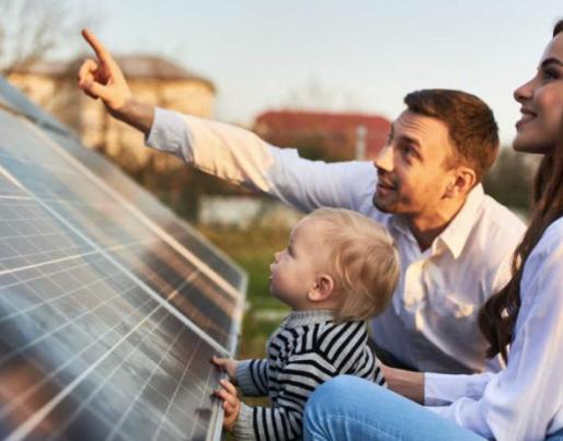 A woman, a man and a baby with a solar panel installation.