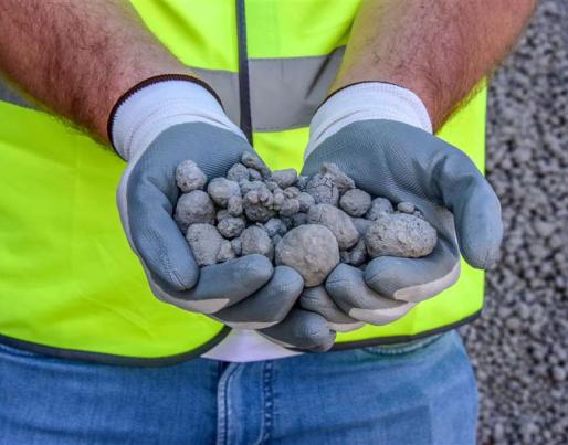 A worker shows pieces of limestone produced using CO2