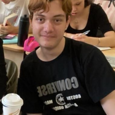 teen boy in black tshirt, with light brown hair, smiling