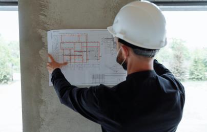 A construction worker consulting a blueprint