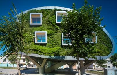 Modern building with curved and green façades