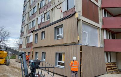 Two construction workers supervising building envelope renovation