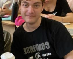 teen boy in black tshirt, with light brown hair, smiling