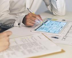 People working together with plans on tablets