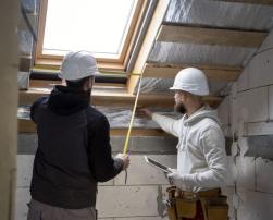 Workers working on thermal insulation of a building