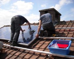 Workers on a roof with solar panels 