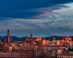 The image shows the skyscraper of a city at sunset