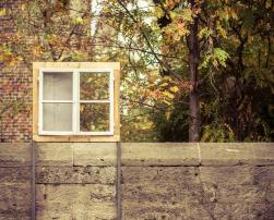 A window on a concrete wall with trees behind