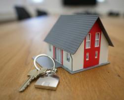 a miniature house and keys on a table