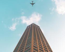 A plane flying over a tall building