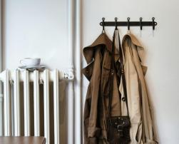 A radiator and coats inside a house