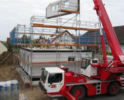 A crane holding a prefabricated facade