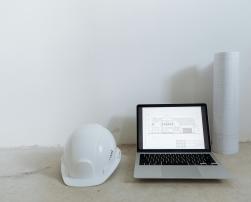 A laptop and a builder's helmet