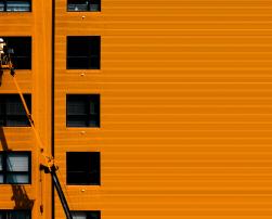 An orange building and a construction worker