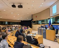 People sitting on a conference room in the European Parliament and speakers giving a speech