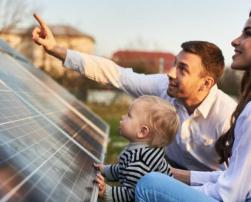 A woman, a man and a baby with a solar panel installation.