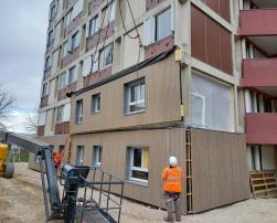 Two construction workers supervising building envelope renovation